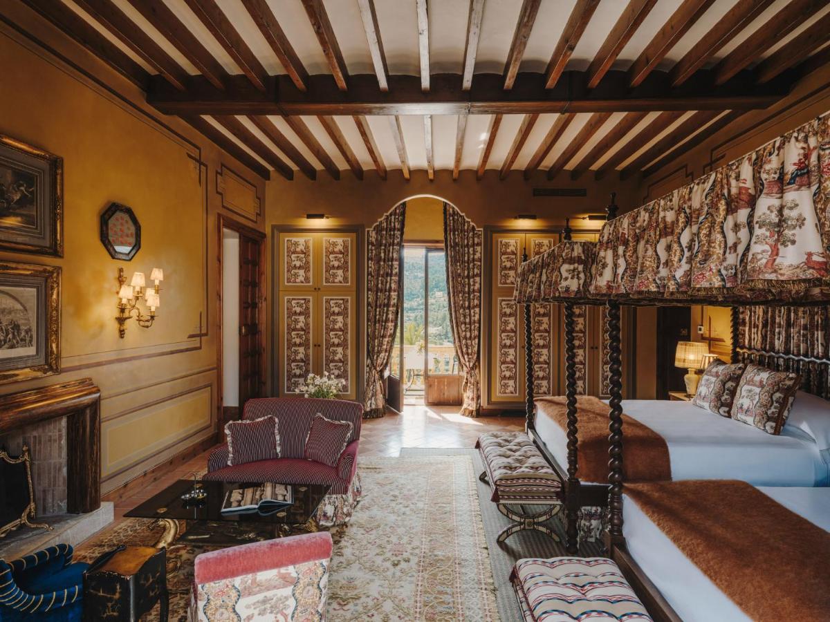 1 dormitorio con 2 camas y chimenea en Grand Hotel Son Net, en Puigpunyent
