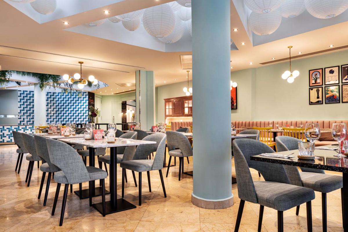 uma sala de jantar com mesas e cadeiras em The Magnolia Hotel na Quinta do Lago