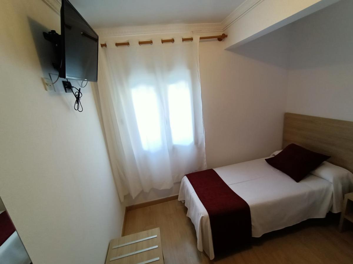 Un dormitorio pequeño con una cama y una ventana. en Hotel Vilobi, en Vilobí d'Onyar