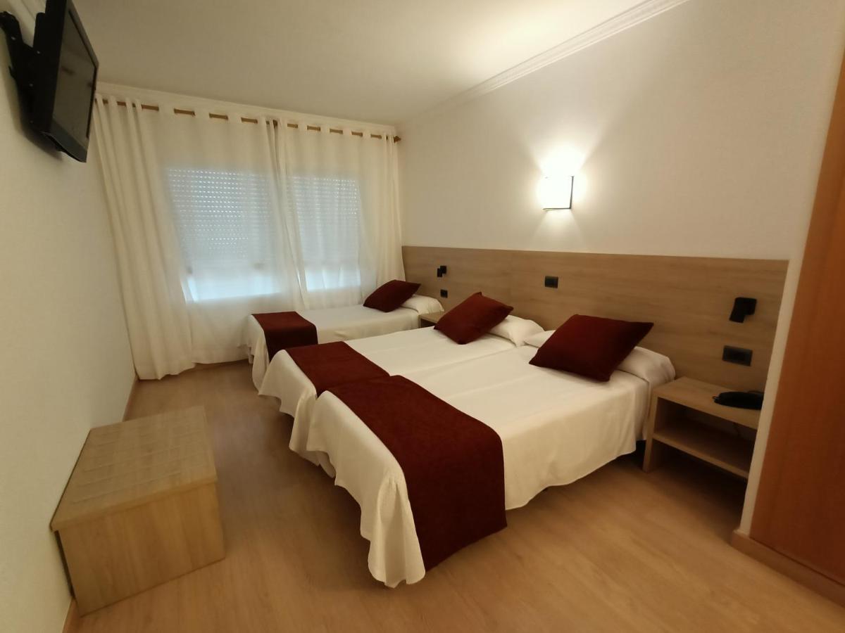 Una habitación de hotel con dos camas y un televisor. en Hotel Vilobi, en Vilobí d'Onyar