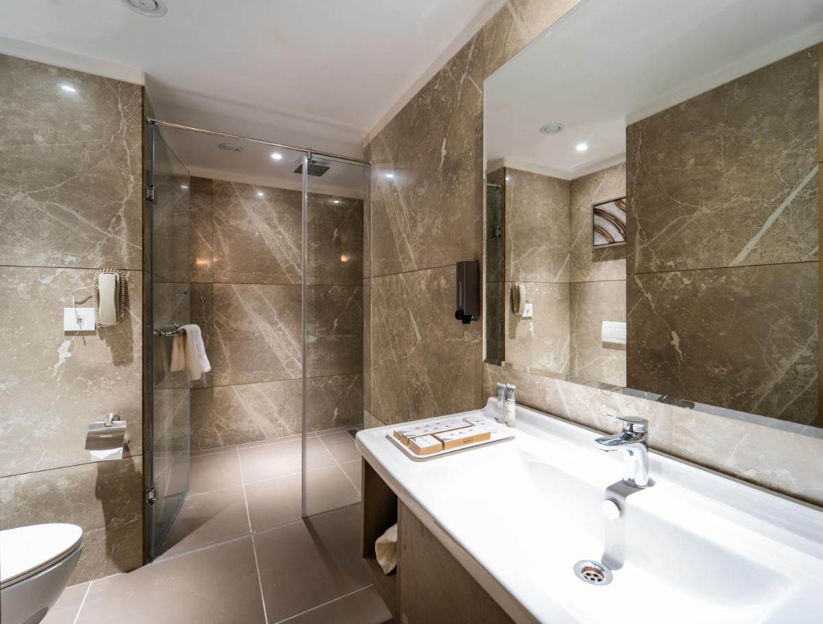 a bathroom with a sink and a shower at Sayaji Pune in Pune