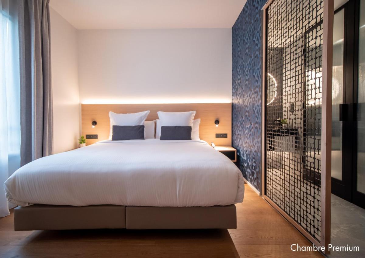 - une chambre avec un grand lit blanc et une douche dans l'établissement Paxton Paris MLV, à Ferrières-en-Brie