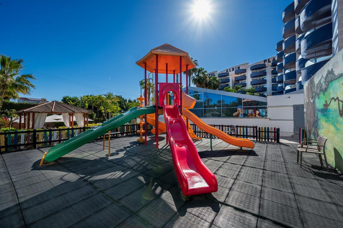 un parque infantil con tobogán en un edificio en Albir Playa Hotel & Spa, en Albir