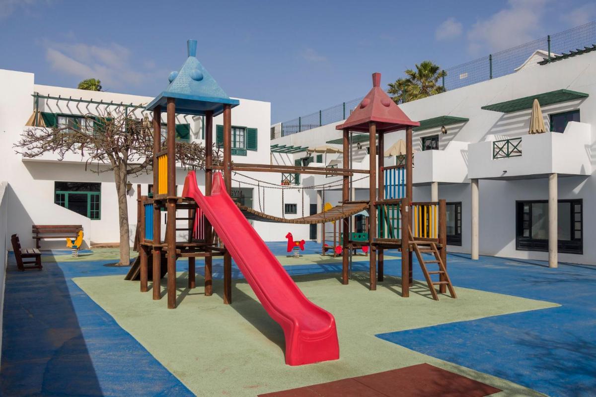 un parque infantil con tobogán en un edificio en ILUNION Costa Sal Lanzarote, en Puerto del Carmen