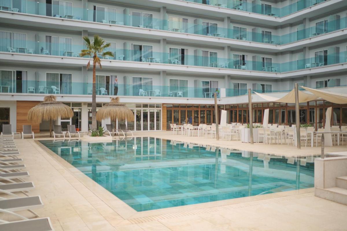 Una piscina de hotel con sillas y sombrillas. en Hotel Bahia del Sol, en Santa Ponsa