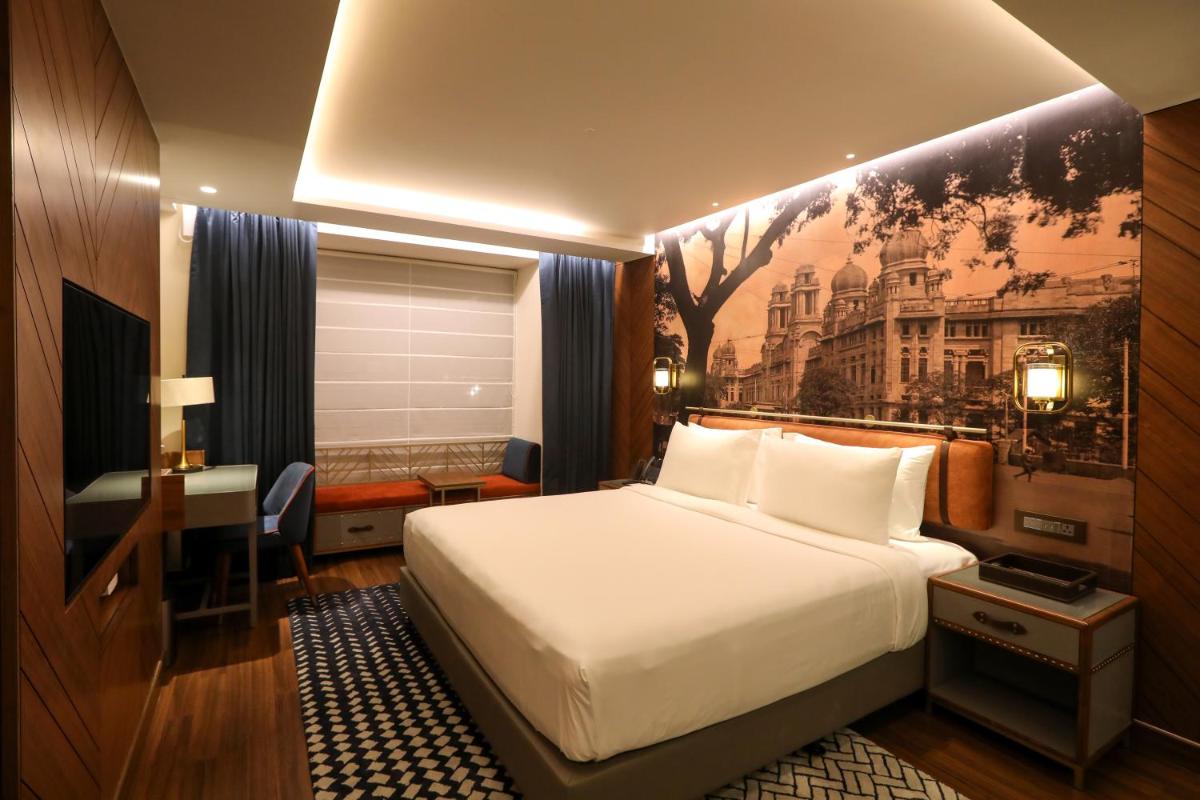 a hotel room with a bed and a desk and a desk at Radisson Blu Hotel & Suites GRT Chennai in Chennai