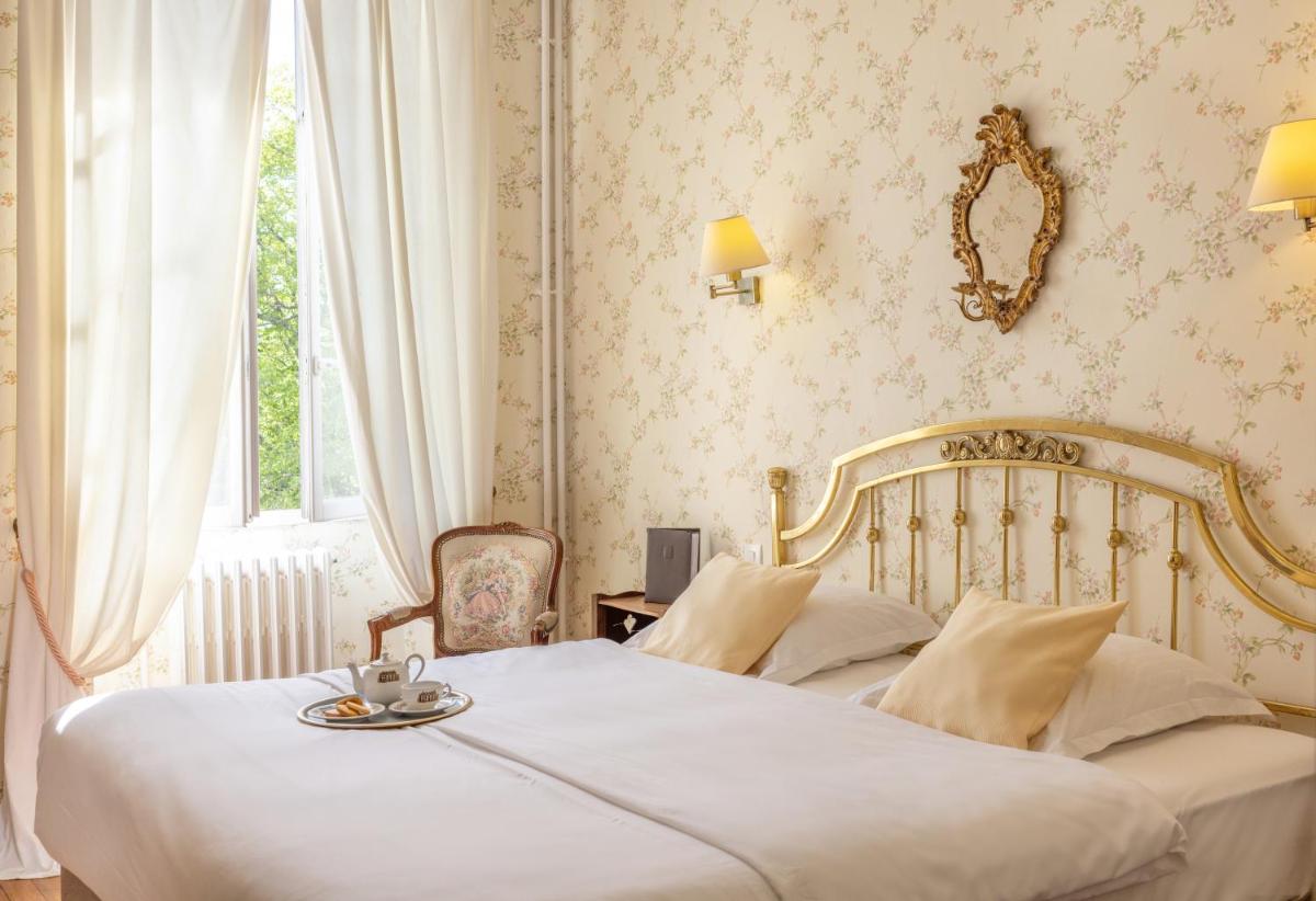 Un ou plusieurs lits dans un hébergement de l'établissement Logis Hôtel Restaurant Château Bellevue
