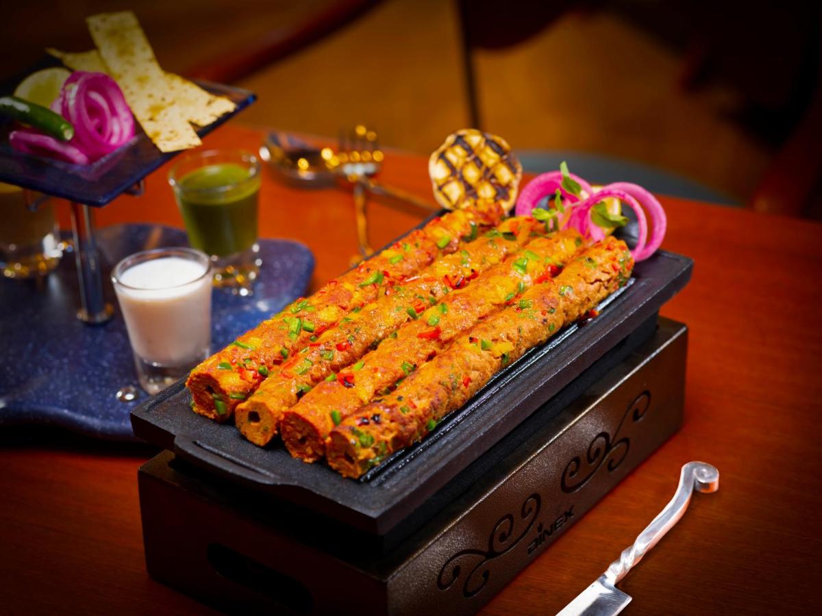 a table with a bunch of food on a table at Radisson Blu Hotel & Suites GRT Chennai in Chennai
