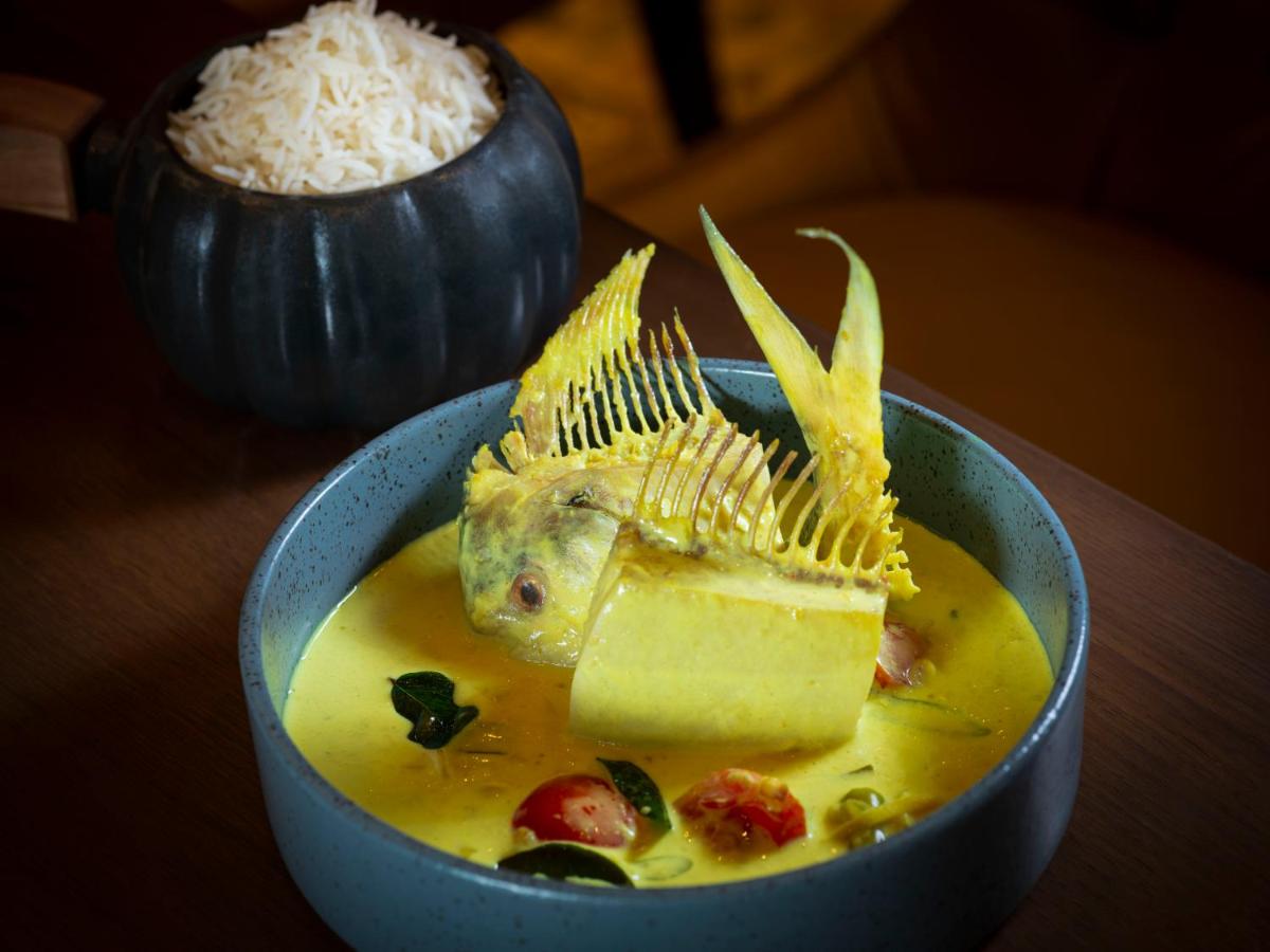 a bowl of soup with a fish on top of it at Radisson Blu Hotel & Suites GRT Chennai in Chennai
