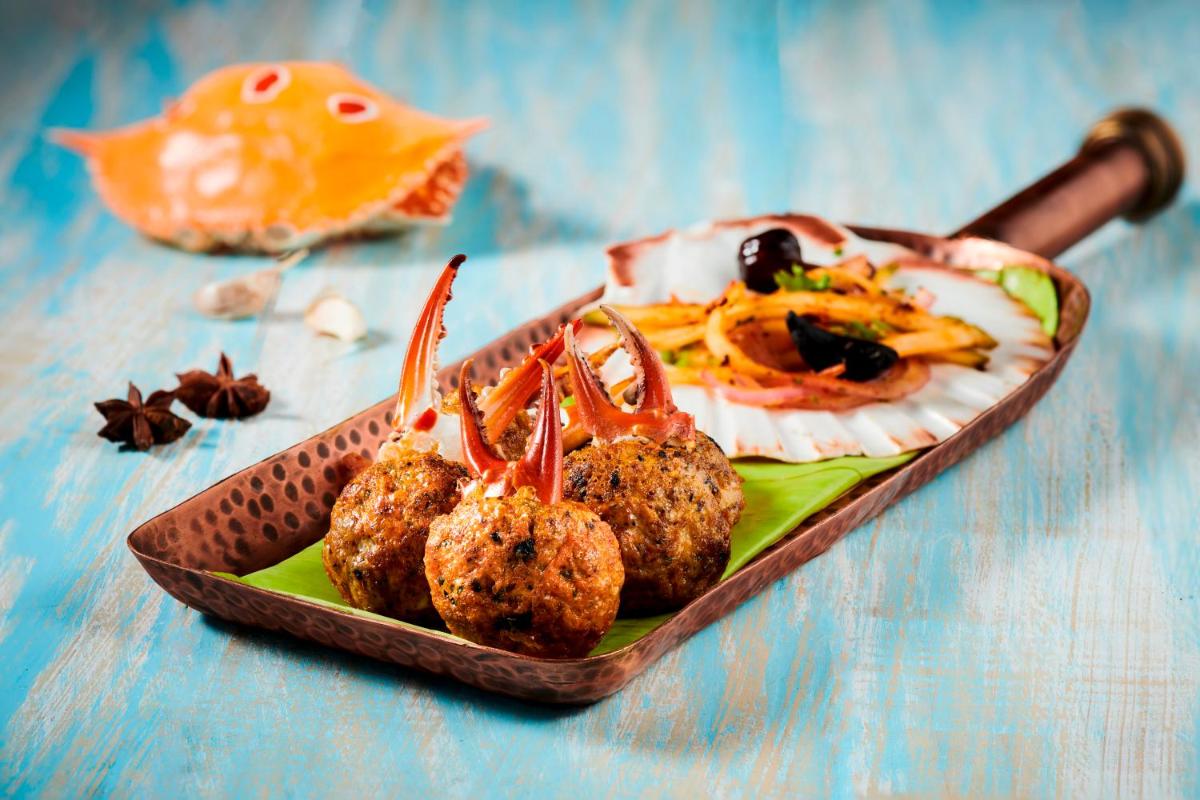a plate of food with meatballs on a table at Radisson Blu Hotel & Suites GRT Chennai in Chennai