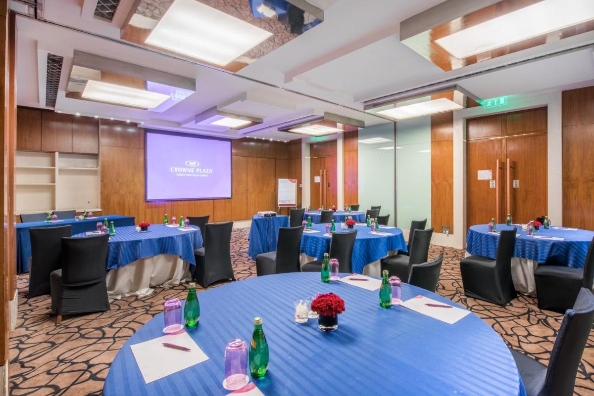 a conference room with blue tables and chairs and a screen at Crowne Plaza New Delhi Okhla by IHG in New Delhi