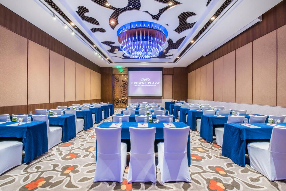 a banquet hall with blue tables and white chairs at Crowne Plaza New Delhi Okhla by IHG in New Delhi