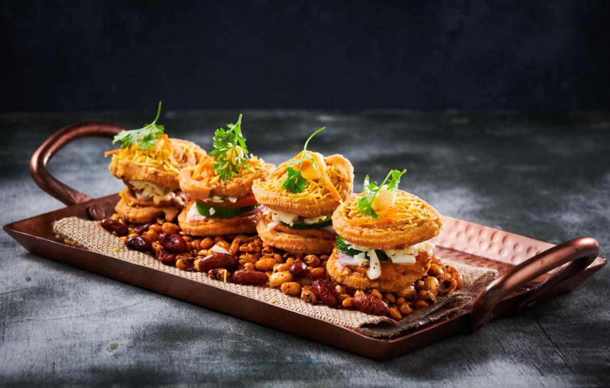 a plate with a pile of sandwiches and beans at Radisson Blu Hotel & Suites GRT Chennai in Chennai