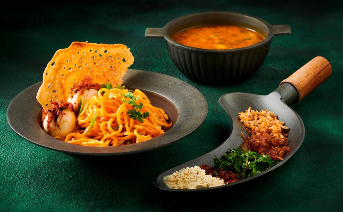 a plate of food with pasta and a bowl of soup at Radisson Blu Hotel & Suites GRT Chennai in Chennai