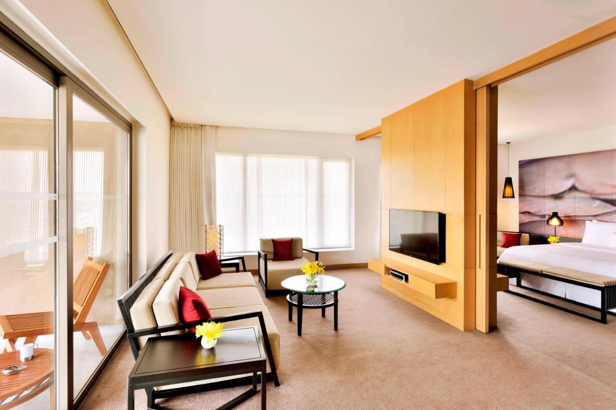 a living room with a couch and a bed and a television at The Westin Hyderabad Mindspace in Hyderabad