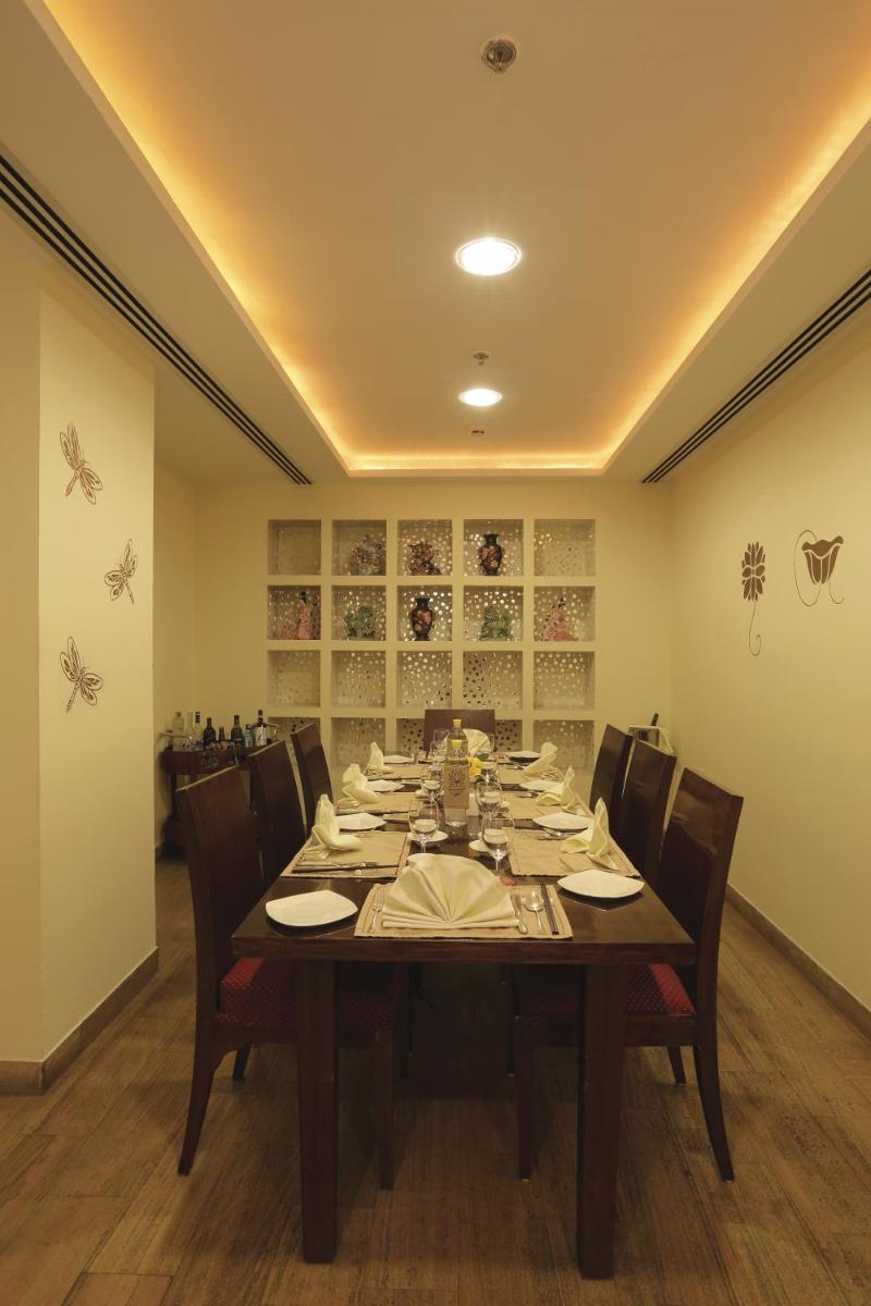 a dining room with a long table and chairs at Radisson Jaipur City Center in Jaipur