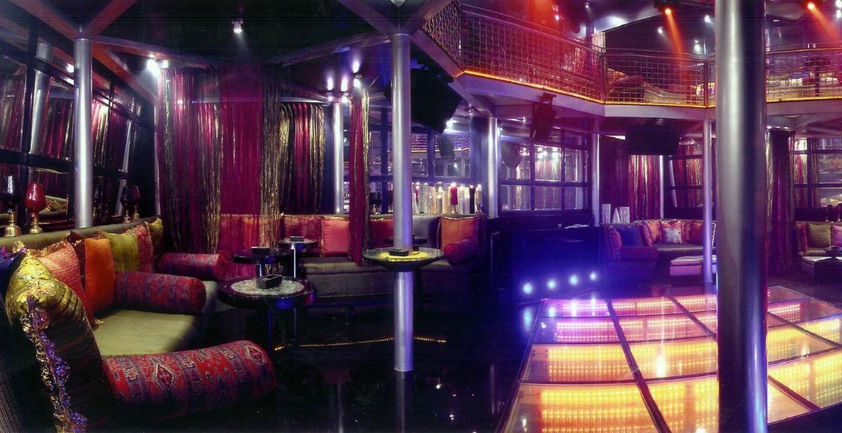 a room with a bar with red chairs and tables at The Park Chennai in Chennai a room with a bar with red chairs and tables at The Park Chennai in Chennai