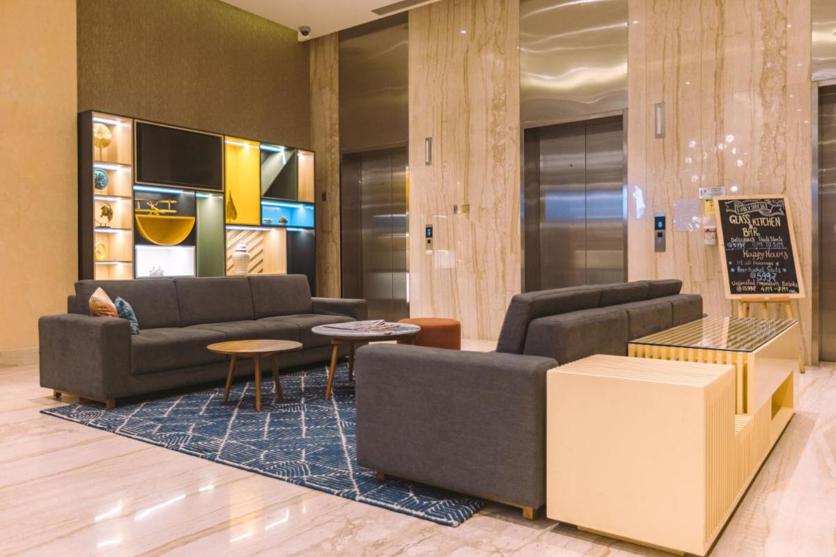 a living room with two couches and a table at Holiday Inn Bengaluru Racecourse by IHG in Bengaluru a living room with two couches and a table at Holiday Inn Bengaluru Racecourse by IHG in Bengaluru