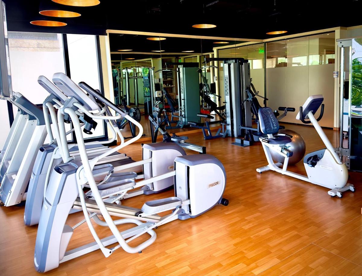 a gym with a bunch of treadmills and machines at Holiday Inn Bengaluru Racecourse by IHG in Bengaluru a gym with a bunch of treadmills and machines at Holiday Inn Bengaluru Racecourse by IHG in Bengaluru