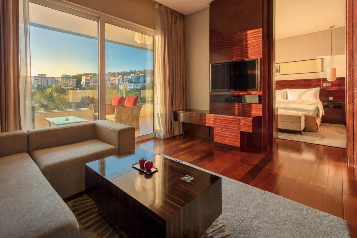 a living room with a couch and a bed and a television at JW Marriott Pune in Pune