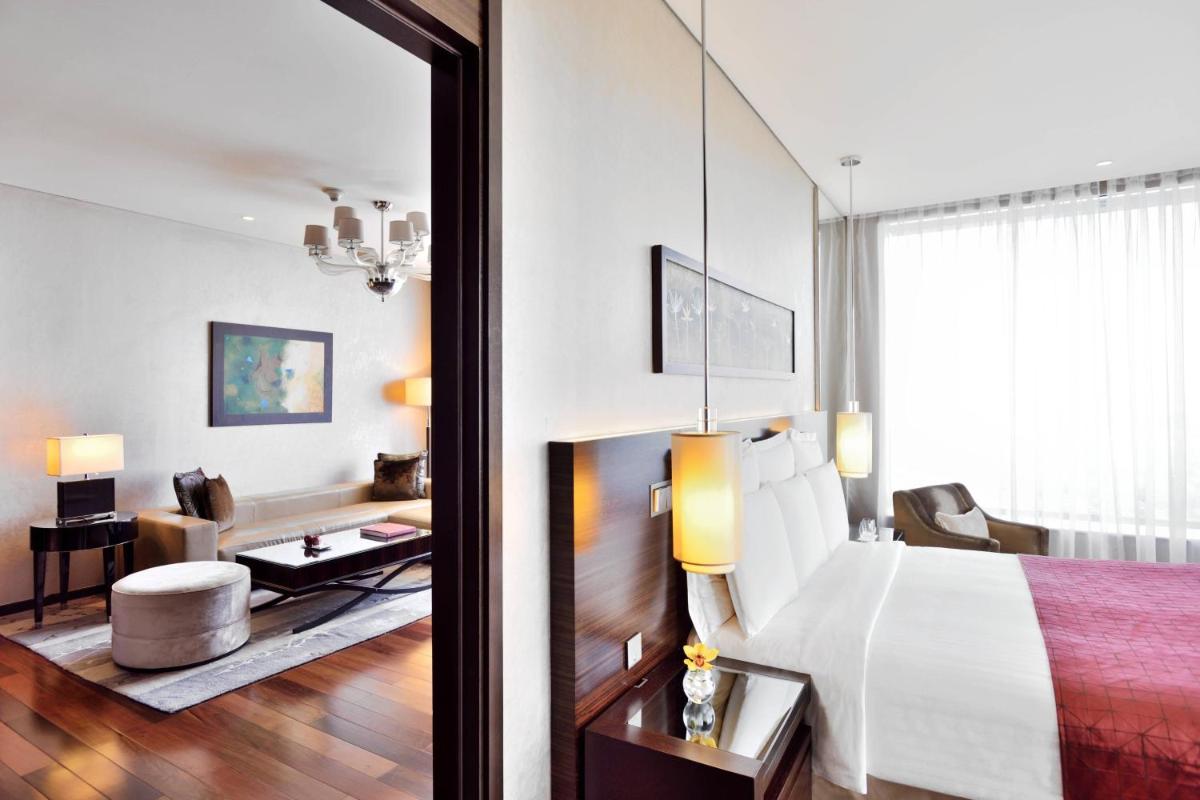 a bedroom with a large bed and a living room at JW Marriott Pune in Pune