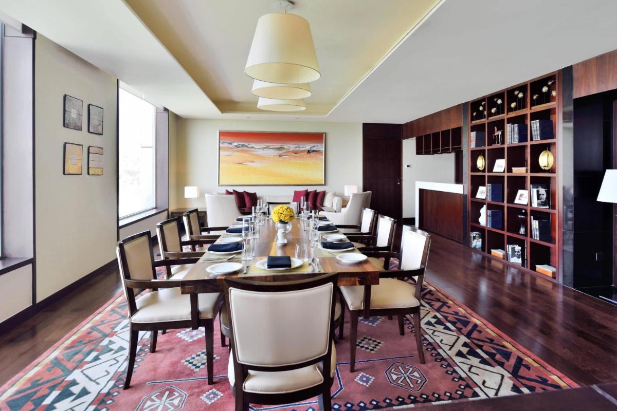 a dining room with a long table and chairs at JW Marriott Pune in Pune