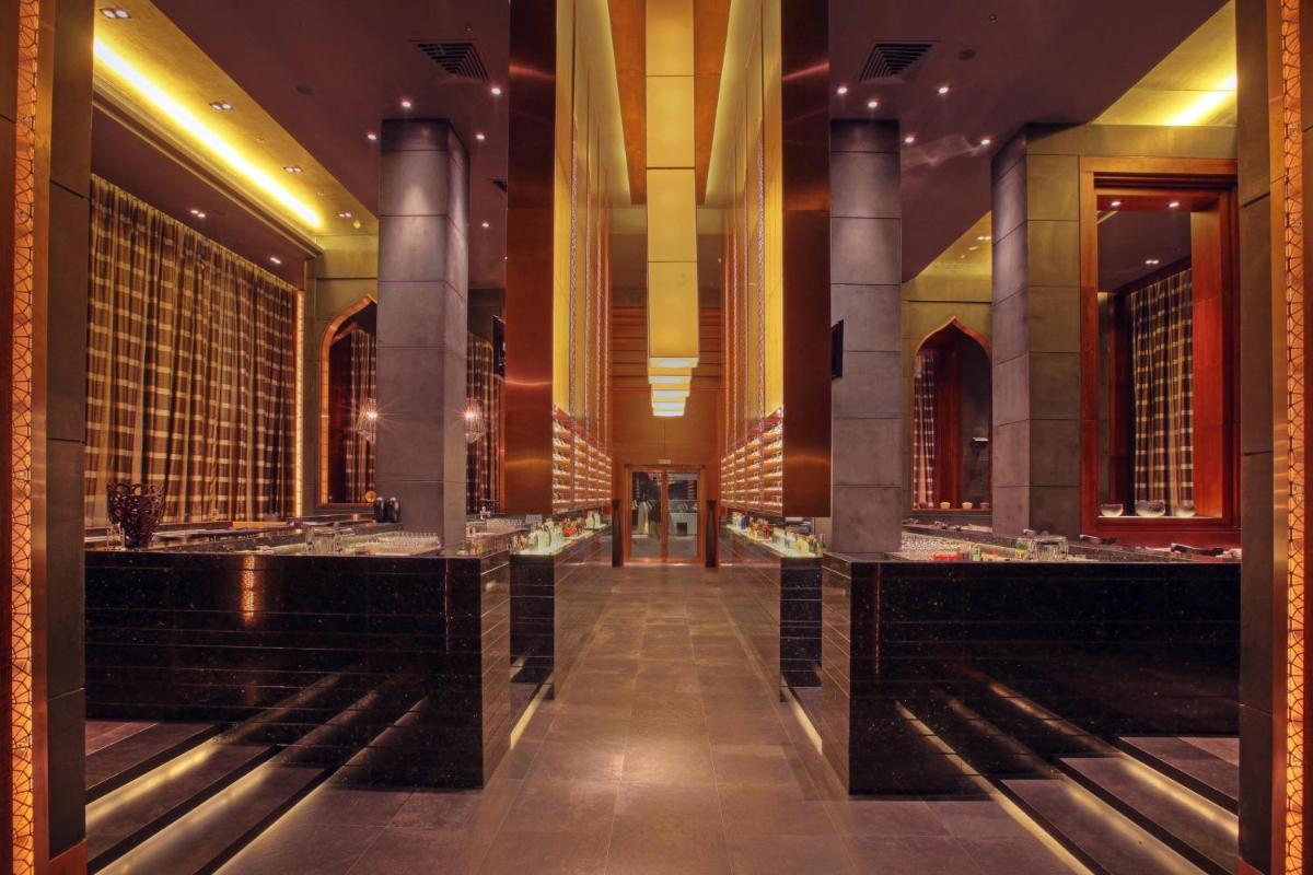 a lobby of a hotel with black counters and columns at JW Marriott Pune in Pune