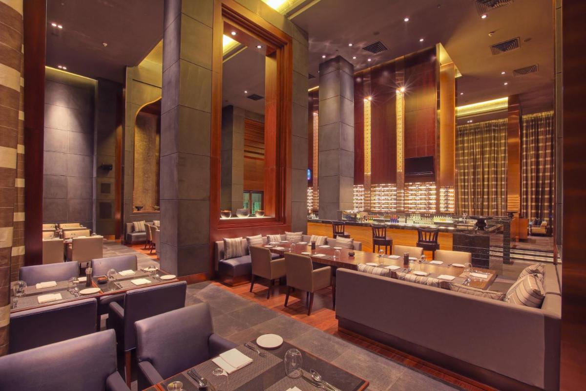 a restaurant with tables and chairs in a room at JW Marriott Pune in Pune