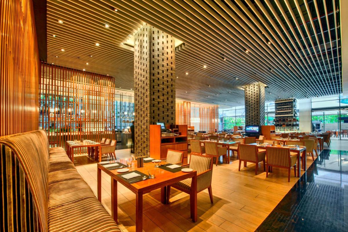a dining room with tables and chairs in a restaurant at JW Marriott Pune in Pune