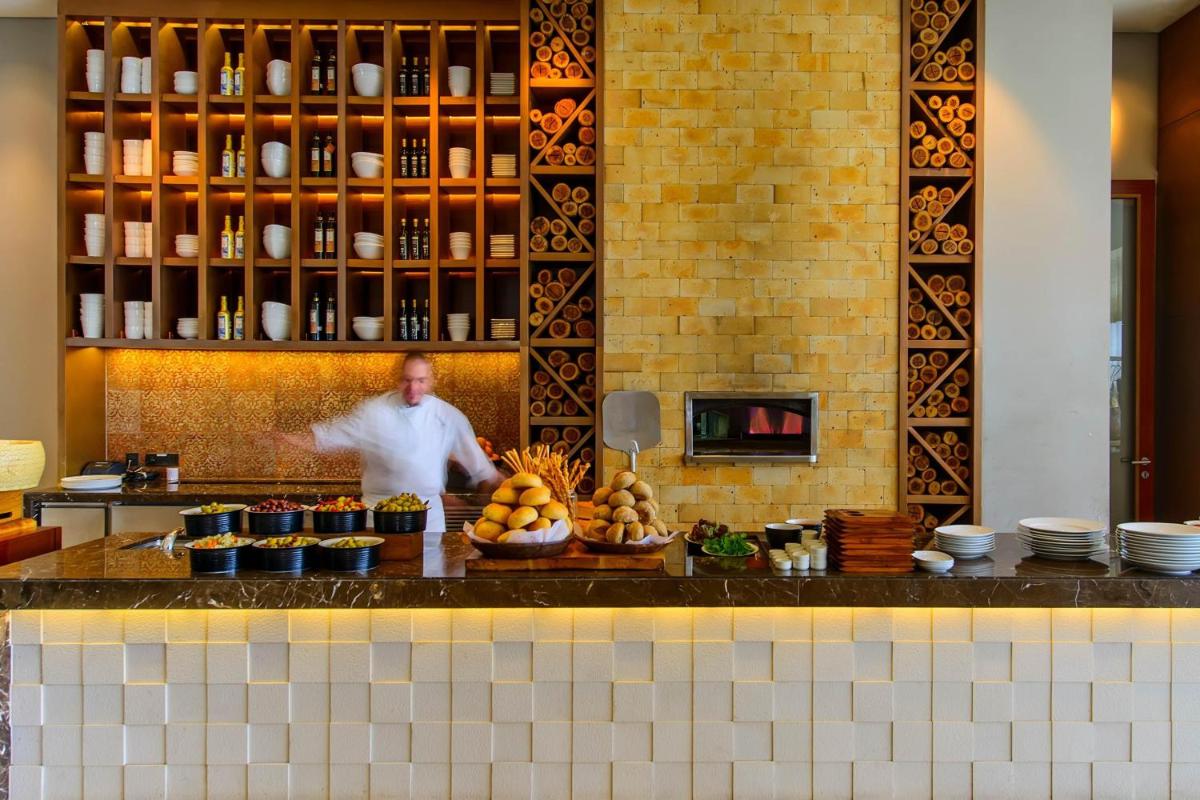 a man standing behind a counter with food on it at JW Marriott Pune in Pune