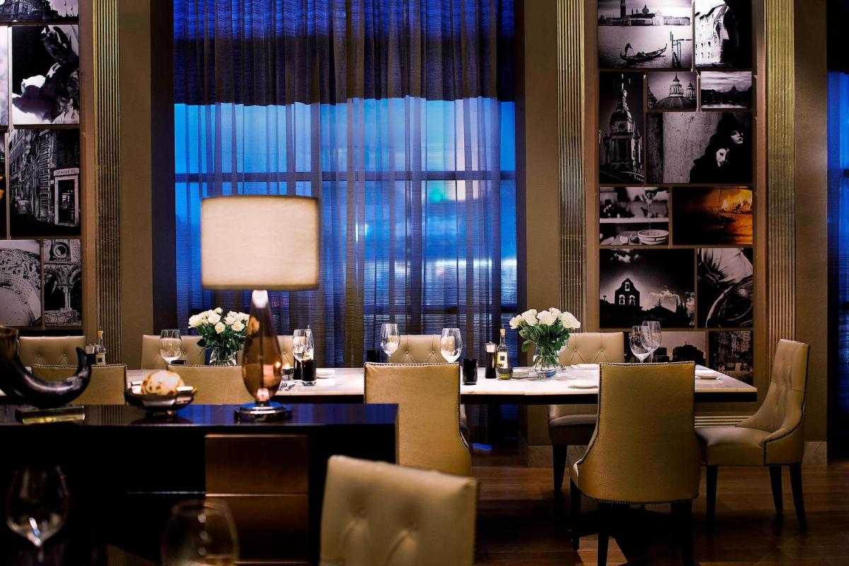 a dining room with a table and chairs and a window at JW Marriott Pune in Pune
