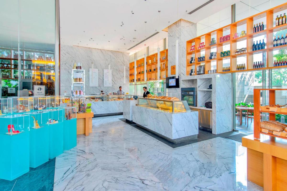 a restaurant with a counter and tables in a room at JW Marriott Pune in Pune