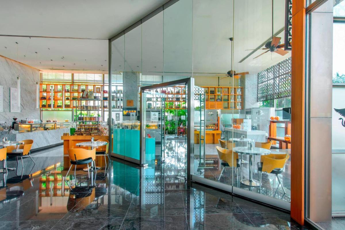 a restaurant with yellow chairs and tables and windows at JW Marriott Pune in Pune