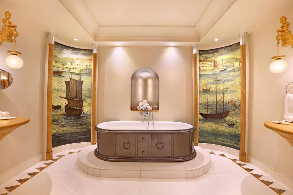 a round tub in a room with paintings on the walls at ITC Maratha, a Luxury Collection Hotel, Mumbai in Mumbai