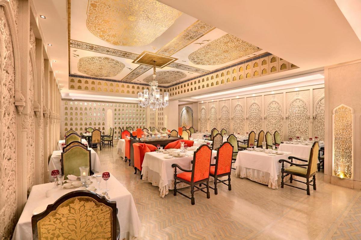 a restaurant with tables and chairs and a chandelier at ITC Maratha, a Luxury Collection Hotel, Mumbai in Mumbai