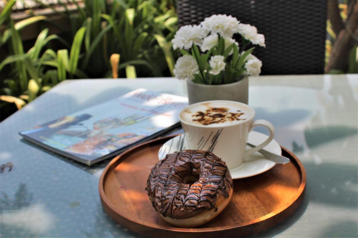 a donut and a cup of coffee on a table at Crowne Plaza Ahmedabad City Centre by IHG in Ahmedabad