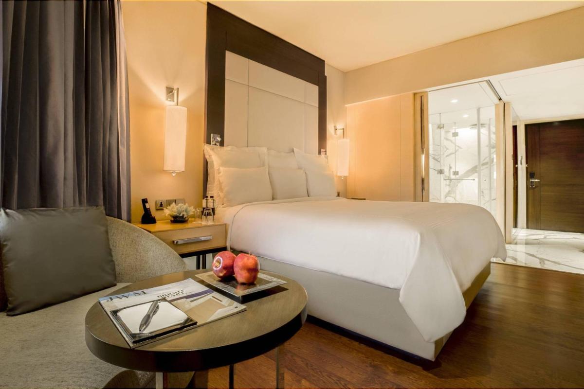 a hotel room with a large bed and a table at JW Marriott Mumbai Juhu in Mumbai