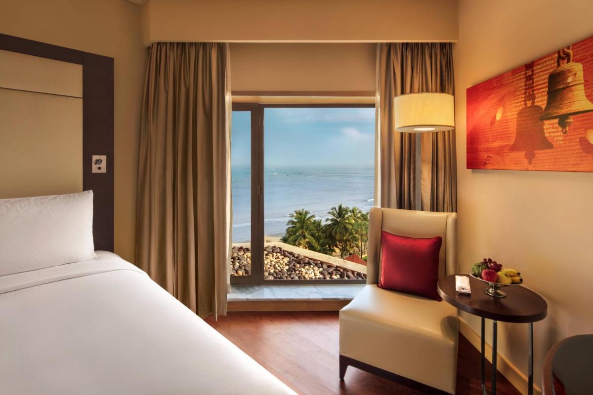 a bedroom with a bed and a view of the ocean at JW Marriott Mumbai Juhu in Mumbai