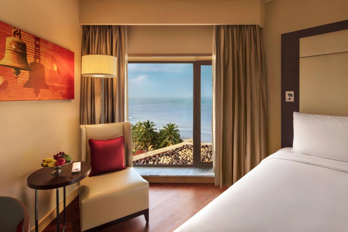 a hotel room with a bed and a view of the ocean at JW Marriott Mumbai Juhu in Mumbai