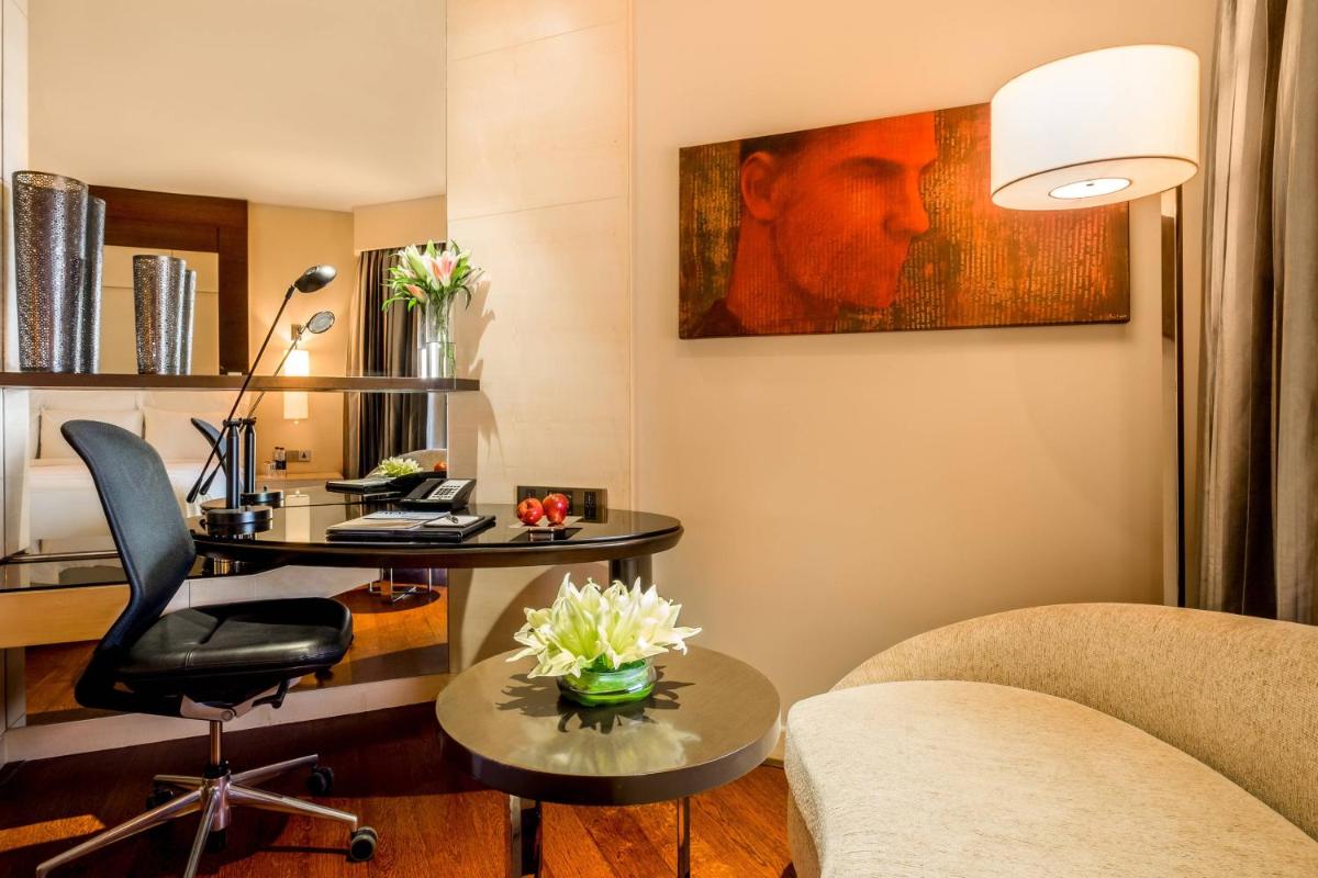 a living room with a desk and a chair and a painting at JW Marriott Mumbai Juhu in Mumbai