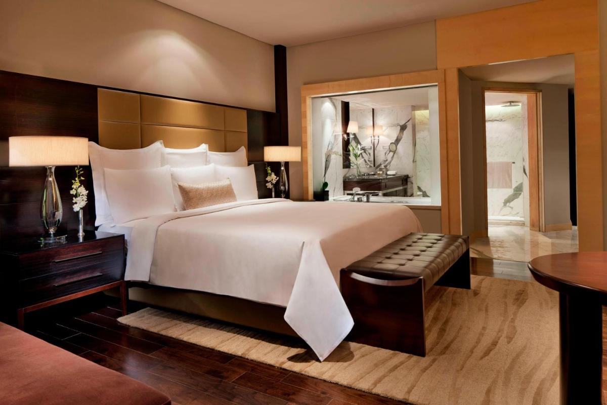 a large bedroom with a large bed and a table at JW Marriott Mumbai Juhu in Mumbai