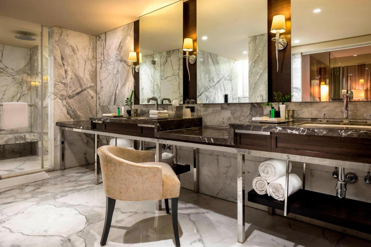 a bathroom with a counter and two sinks and a chair at JW Marriott Mumbai Juhu in Mumbai