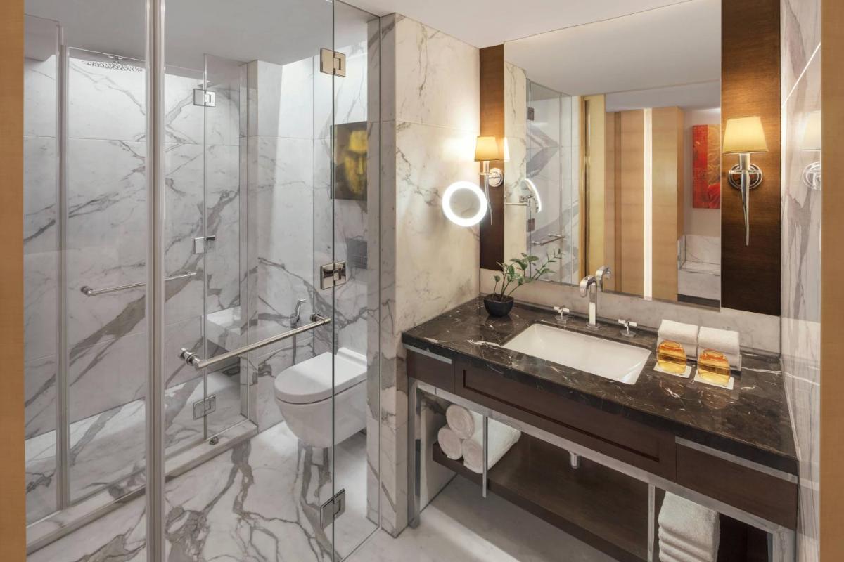 a bathroom with a toilet and a sink and a shower at JW Marriott Mumbai Juhu in Mumbai