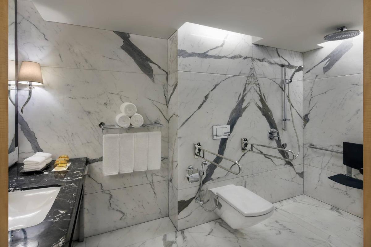 a bathroom with a toilet and a sink at JW Marriott Mumbai Juhu in Mumbai