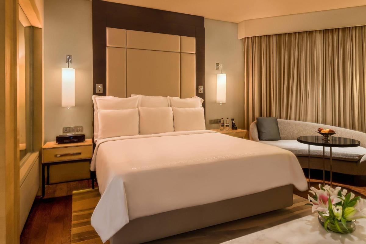 a hotel room with a large bed and a couch at JW Marriott Mumbai Juhu in Mumbai