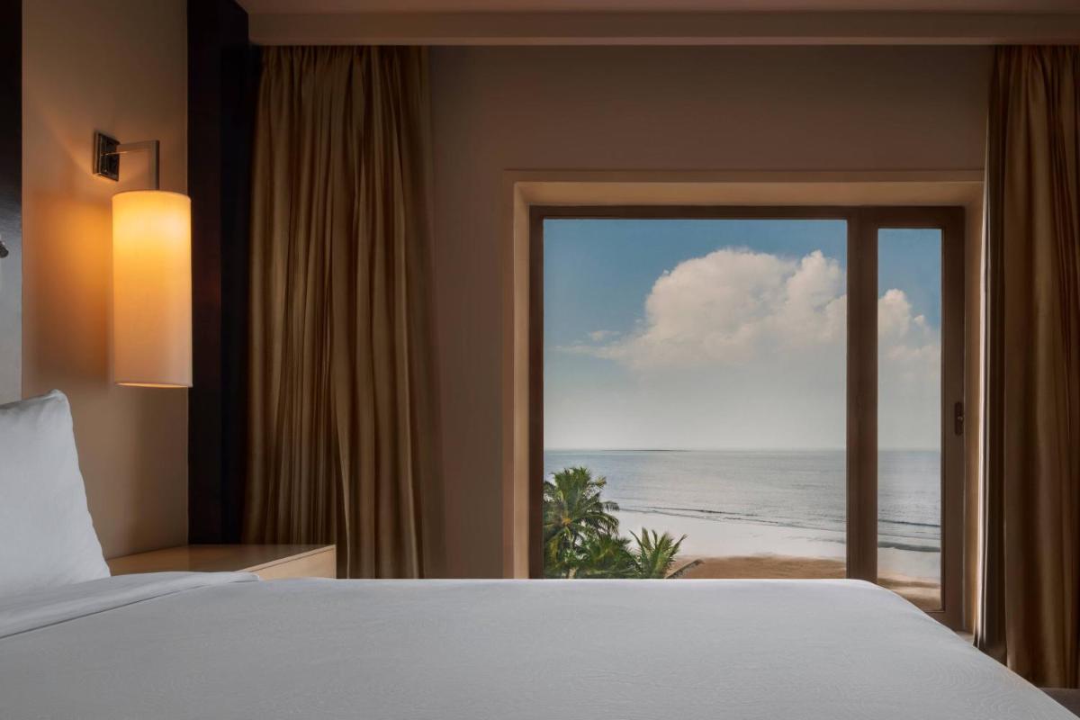 a bedroom with a bed and a view of the ocean at JW Marriott Mumbai Juhu in Mumbai