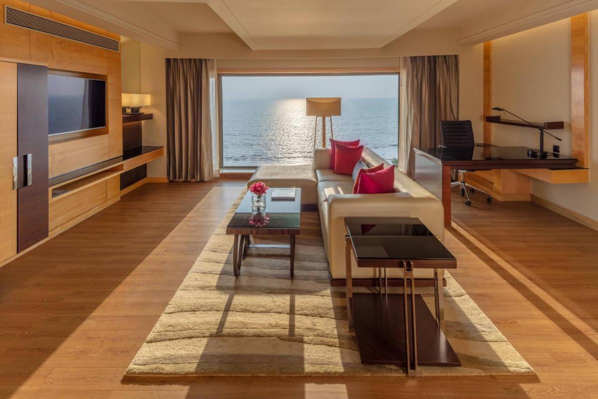 a living room with a couch and a piano at JW Marriott Mumbai Juhu in Mumbai