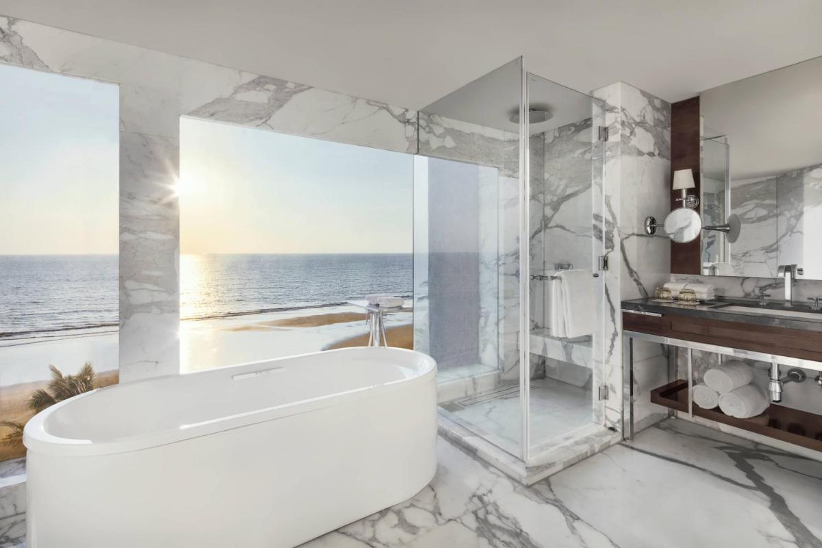 a white bathroom with a tub and a shower at JW Marriott Mumbai Juhu in Mumbai