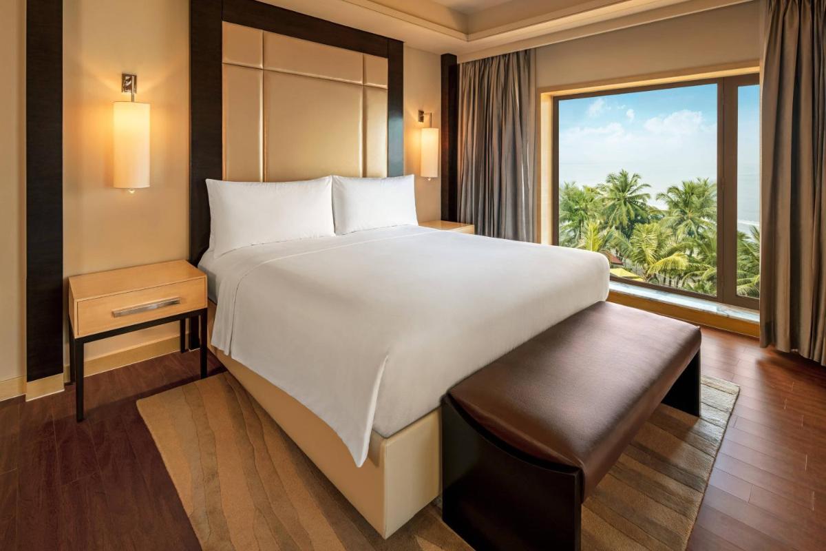 a bedroom with a large bed and a large window at JW Marriott Mumbai Juhu in Mumbai