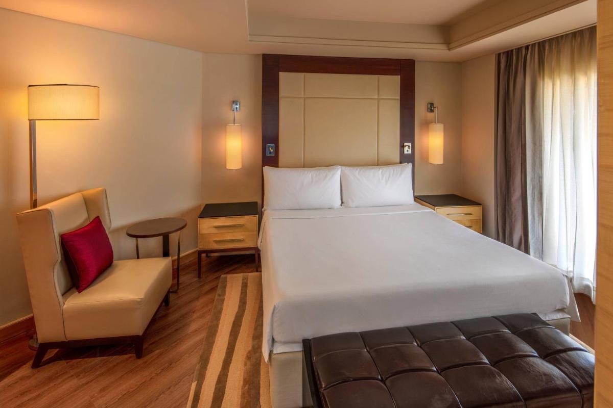 a hotel room with a large bed and a chair at JW Marriott Mumbai Juhu in Mumbai